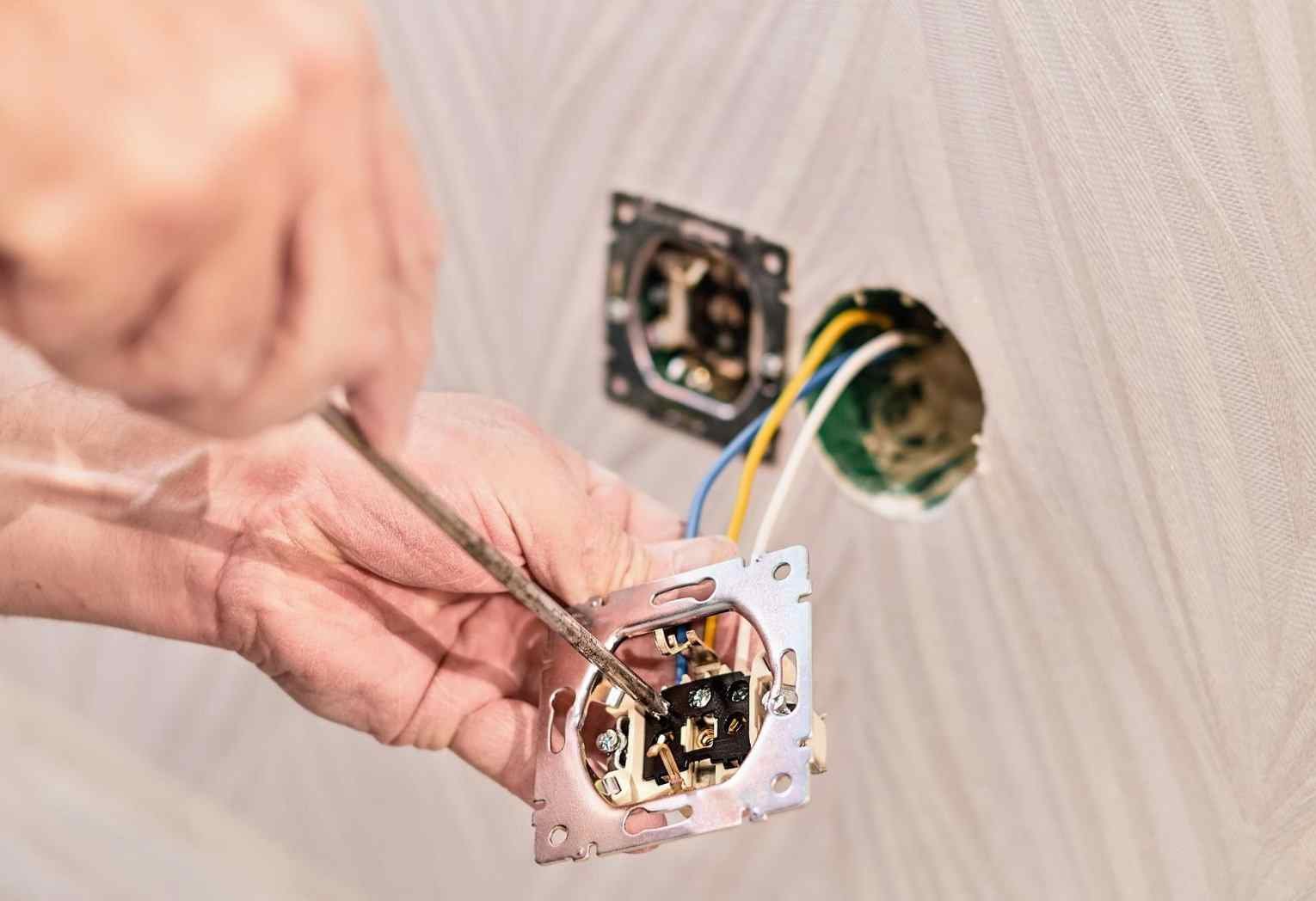 Professional electrician installing electrical socket